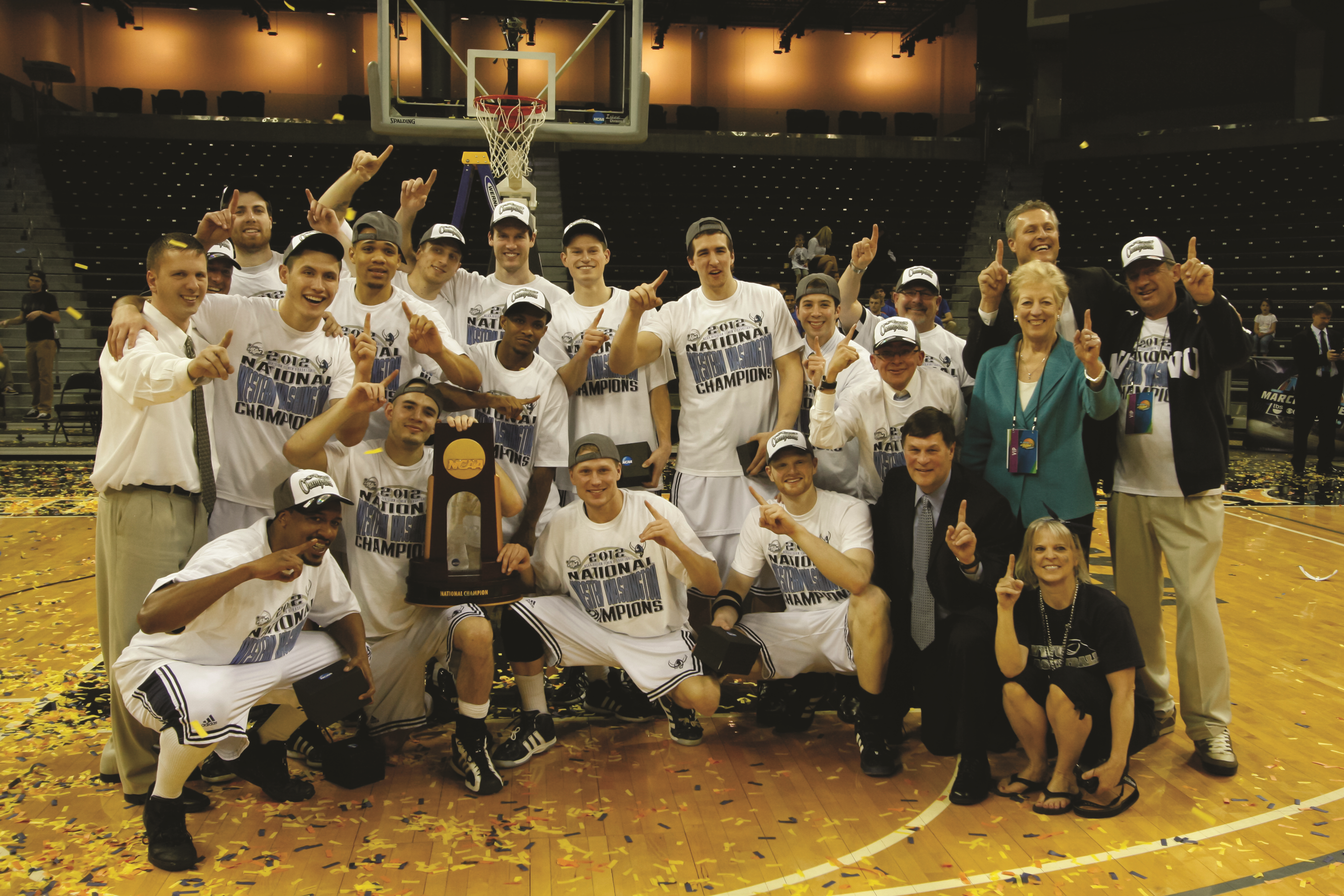 Members of Western&#039;s men&#039;s basketball team are wearing t-shirts that read &quot;national champions&quot; and holding a trophy