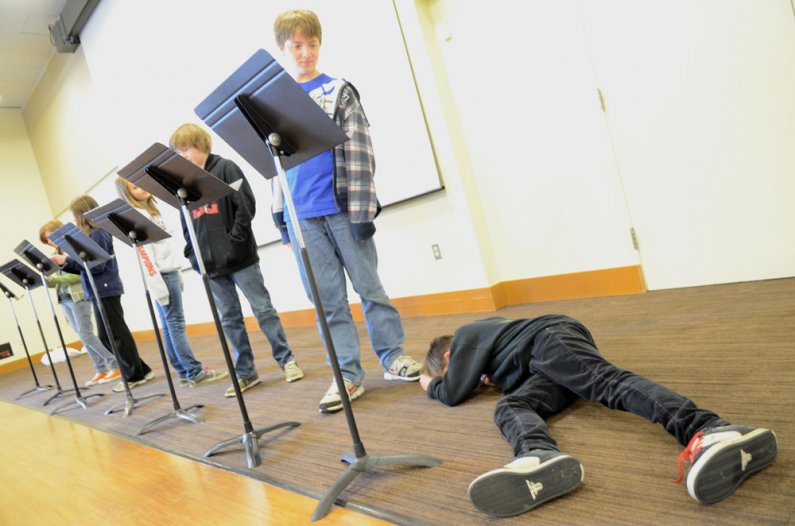 Whatcom Middle School sixth grader Trevor Moore plays the fallen Icharus during a reading of a Greek novel inside the Viking Union Multipurpose Room during a tour of the Western Washington University campus Thursday, May 26. The tour  was a collaboration 
