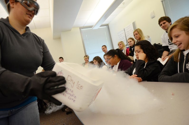 Western Washington University chemistry major Michelle Marsura pours dry ice vapor onto a table during the science experiment part of a tour of the WWU campus Thursday, May 26. A number of Whatcom Middle School students toured the university in a collabor