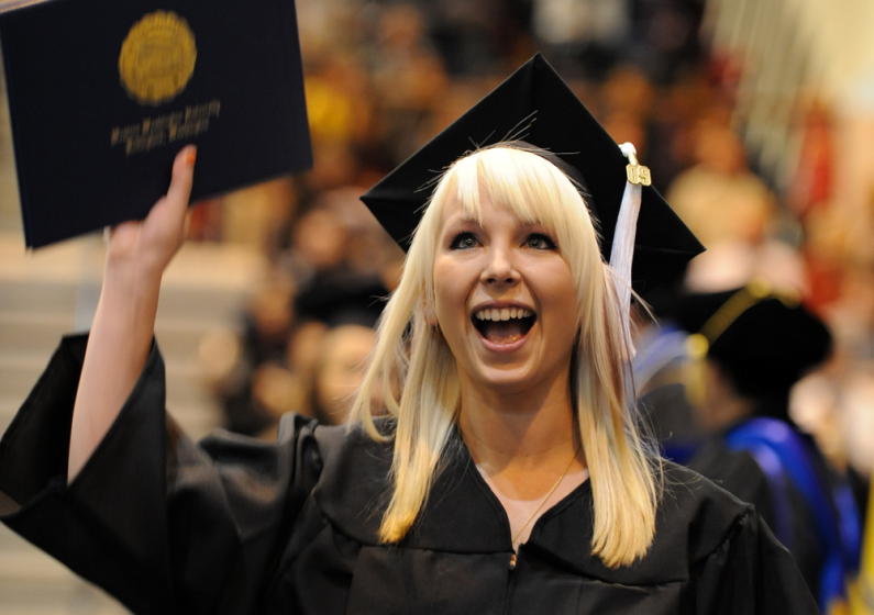 Graduate Cara Alboucq shows her family and friends her diploma as she walks back to seat during the fall 2009 commencement at Western Washington University. Photo by Rachel Bayne