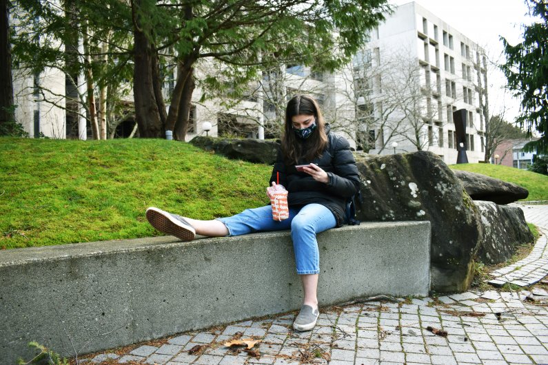 Public Relations major Elizabeth Mahan of Spokane sits down to get some fresh air and watch Youtube as she takes a little break between Zoom classes on Jan. 6, 2021. 