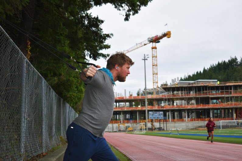 A student works out next to the fence around Western's track.