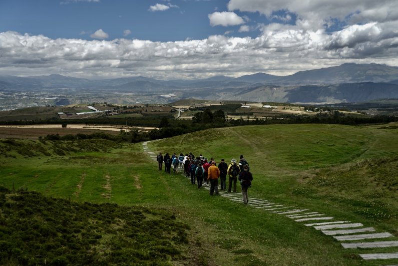 Students and instructors walk down a hillside around Cochasqui. Sean Patrick/WWU