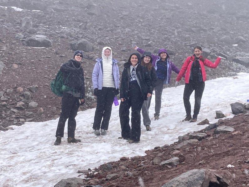 A group of students smiles in the sleet as they hike up Chimborazo.