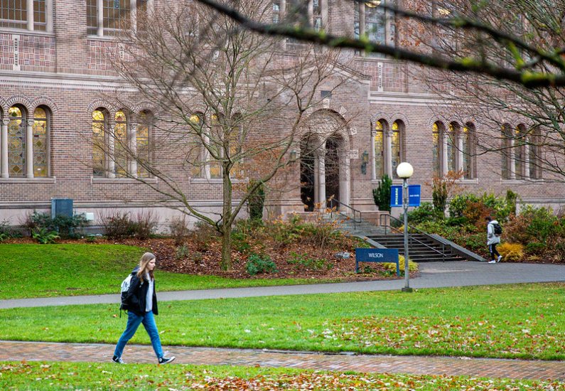 Student walking on a path in front of Wilson Library