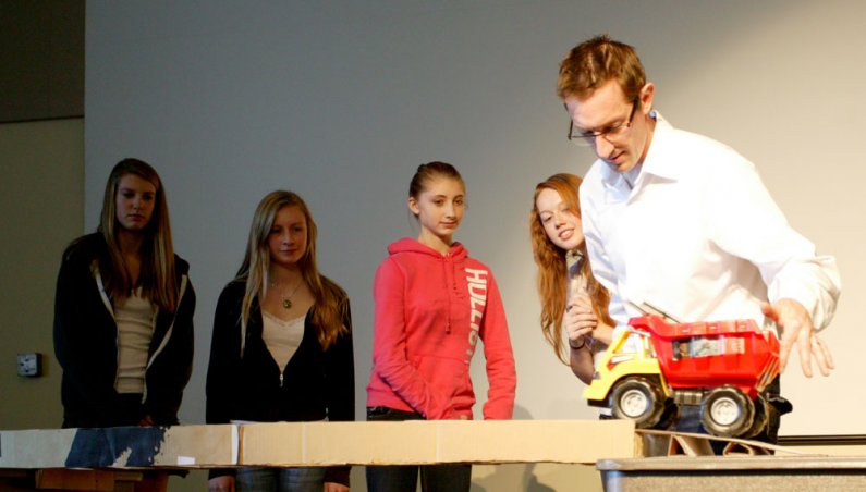 Sehome High School students Erika Smith, Paige Hauter, Frances Flinn and Leta Ames watch as Jason Morris, an associate professor of engineering technology, pushes a truck across their bridge during a competition at WWU on Oct. 19, 2010.  Photo by Matthew 