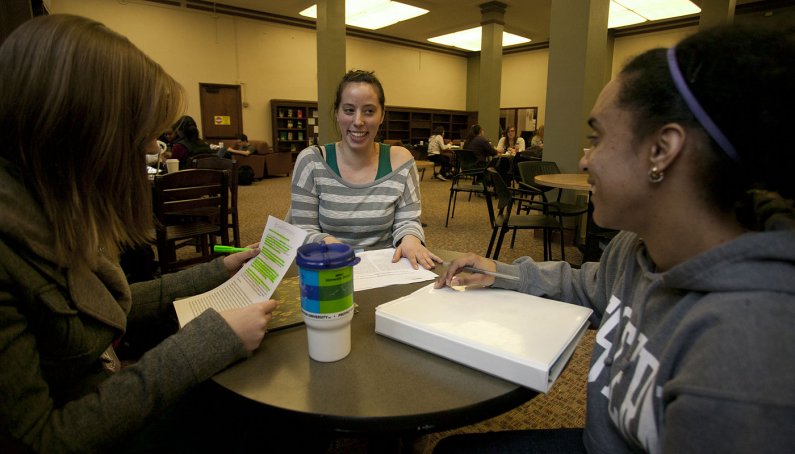 Erin Cheatum laughs with friends Kathryn Kennedy and Lorryn Whisnant while studying in Zoe's in Wilson Library. Photo by Matthew Anderson | WWU