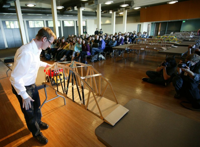 Associate professor Jason Morris tests one of the bridges entered in the bridge-building contest in the Viking Union Multipurpose Room on Oct. 19, 2010. Students from WWU and Sehome High School were competing. Photo by Matthew Anderson | University Commun