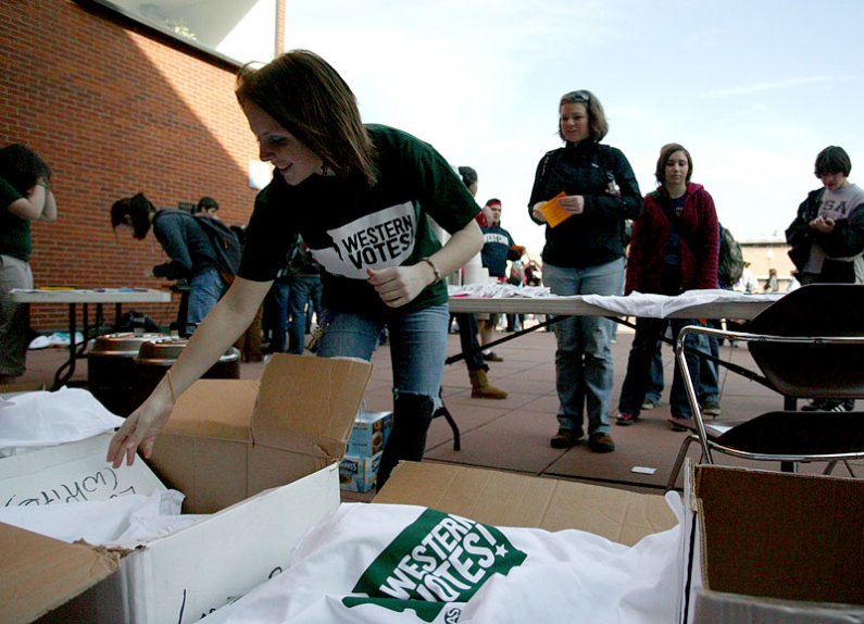 During a rally on campus Friday, Feb. 5, Western Washington University student Rachel Bowers, left, hands Western Votes! T-shirts to fellow students, who  plan to wear them in a rally planned for Feb. 15 in Olympia. Photo by Matthew Anderson | WWU