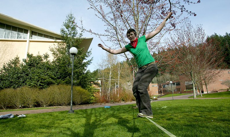 Western Washington University student Ruthie Taylor, left, who is taking a break from attending Fairhaven College of Interdisciplinary Studies, balances on a slackline on the WWU campus March 18, 2010. Photo by Matthew Anderson | WWU