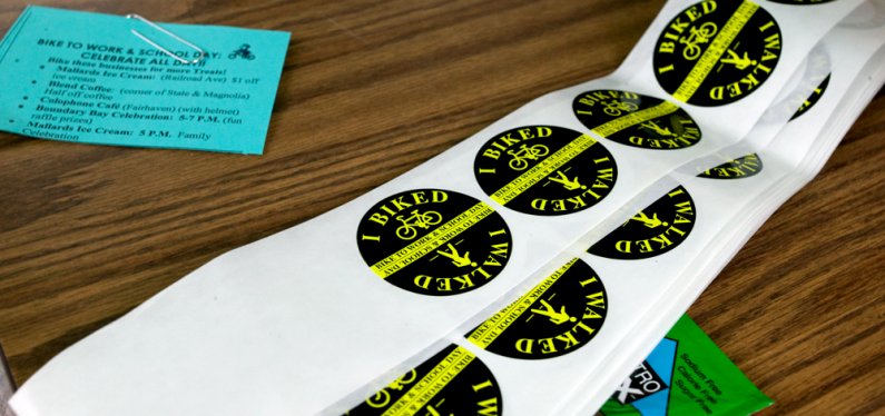 Among the items available for those who walked or biked to work or school on Friday, May 21, were stickers and a list of celebration events happening throughout the day. Tire patch kits, food, ankle straps and bottle openers also were available. Photo by 