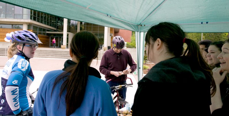 Community member Luke van'T Hoog fills out a raffle entry form while WWU student Sophia Endter-McCloy talks with students and faculty members staffing the celebration station about a funny experience she had earlier in the morning Friday, May 21. Photo by