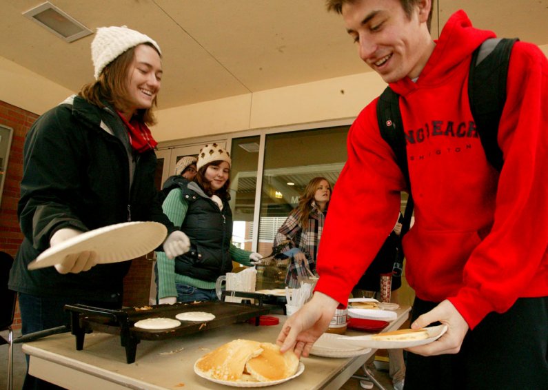 Britney Wight, left, serves pancakes to Grant Bowman outside the Viking Union Multipurpose Room. Wight is from The INN, which is offering free pancakes for those heading in to the AS Campus Activities Showcase. Photo by Matthew Anderson | WWU