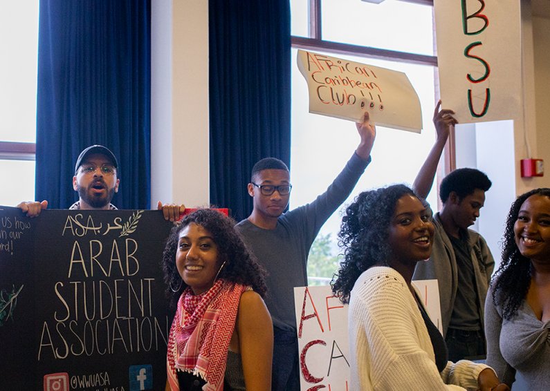 Students from the Arab Student Association, the African Caribbean Club, and the Black Student Union holding signs and recruiting new members at the WWU AS Info Fair on Sep 23. 