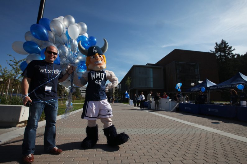 Chris Roselli, assistant director of Alumni Relations at Western Washington University, and Victor the Viking carry a set of balloons during registration at Back 2 Bellingham on May 15, 2010, on the WWU campus. Photo by Mark Malijan | For WWU