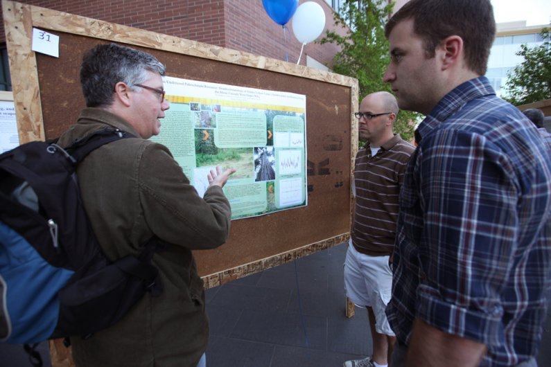 Assistant Professor of Environmental Studies Troy D. Abel, left, and Huxley College of the Environment graduate students Brian Gouran and Chris Robertson discuss a masters project by Robertson at the Association of Washington Geographers Spring Meeting du