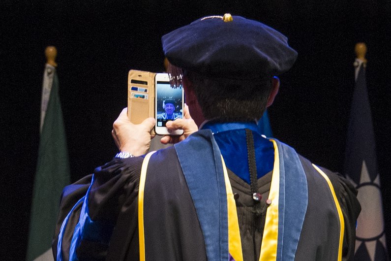 At the urging of student commencement speaker Joseph Eason, WWU president Bruce Shepard takes a selfie onstage at WWU winter commencement March 19. Photo by Dan Levine / for WWU