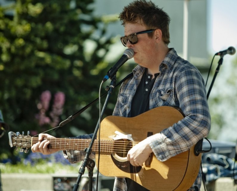 Chris Wise, 25, lead singer for Washington Mile, sings and plays his guitar during the band's performance as part of the Summer Noon Concert series on Wednesday, July 7, 2010, in the Performing Arts Center Plaza on Western Washington University's campus. 