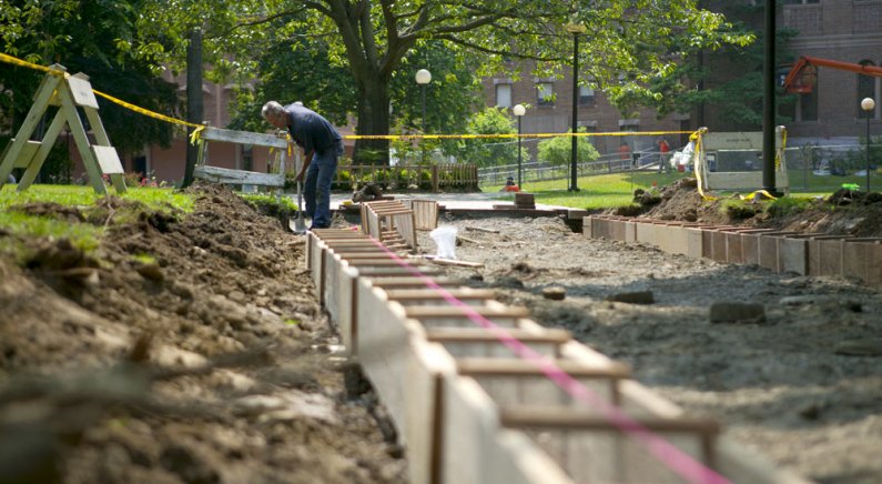 Denny Bouma, a maintenance mechanic with Western Washington University's Facilities Management, digs out space for a concrete footing under one of the brick walkways in front of Old Main on the WWU campus Aug. 4, 2010. The redone pathway will allow for th