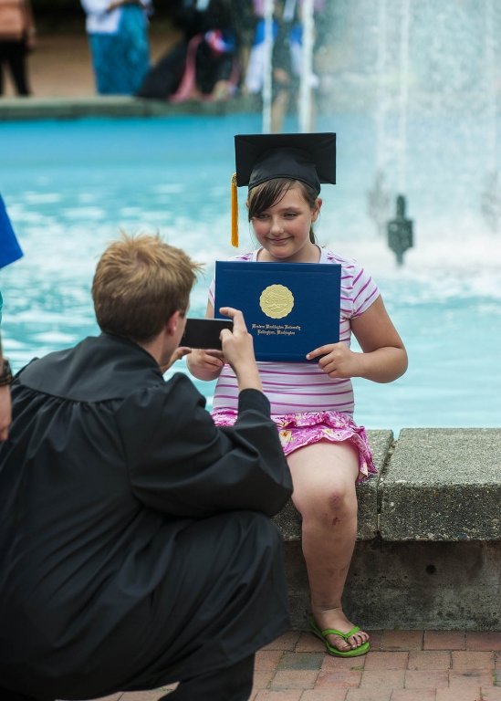 Nicholas E.  Beichley (left) takes a snap shot of his niece Hailie Beichley (age 9) as they celebrate the elder's graduation on June 15, 2013.  Beichley is a computer science major from Tacoma. Photo by Dan Levine | for WWU