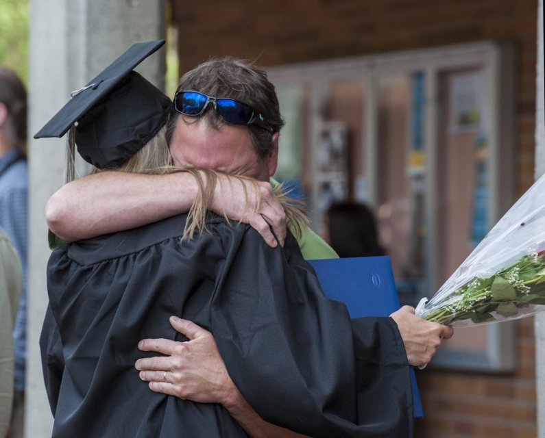 Brian Lord (right) embraces his daughter Paige Lord (left) after graduation ceremonies on June 15th, 2013. Paige is a communication major from LaGrande, Ore. Photo by Dan Levine | for WWU