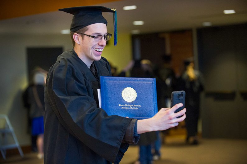 Brek Nebel, who received his MBA on Saturday, poses with his son, Coen, on Saturday. Photo by Dan Levine / for WWU