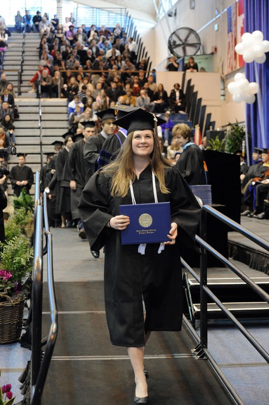 Katrina Ozols smiles at the crowd after receiving her diploma March 19 at winter commencement. Photo by Dan Levine