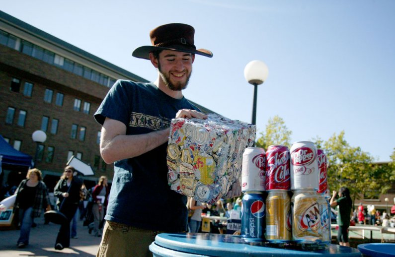 Western Washington University senior Philip Robinson tries to guess how many soda cans are in a crushed block of aluminum at a booth set up by the AS Recycle Center at the Red Square Info Fair on Sept. 21, 2010. The block contains roughly 850 cans. Photo 