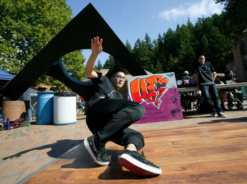 Ethan Leung, a member of the Hip Hip Association club at Western Washington University, dances in front of the Skyviewing Sculpture at the Red Square Info Fair on Tuesday, Sept. 21. Looking on in the background is fellow club member Roman Naval. The club 