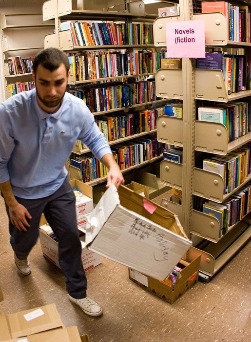 Student volunteer Per Junkerman clears away an empty box once filled with books from Room 171 in Wilson Library. Junkerman is working to fill this small room with as many books as possible for the Children's Literature Book Sale scheduled for Thursday and