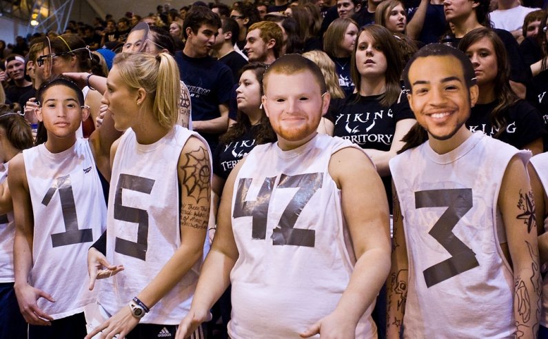 Western Washington University students use cut-out photos of their favorite Viking players to help cheer the home team to victory over the rival Central Washington University during the NCAA Division II West Regional Championship Tournament at Carver Gym 