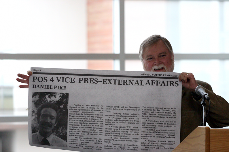 Jim Schuster, director of VU facilities, shows an enlarged copy of a Dan Pike's entry in the Associated Students voters' pamphlet from during Pike's time as a WWU student. Photo by Michael Leese | WWU intern