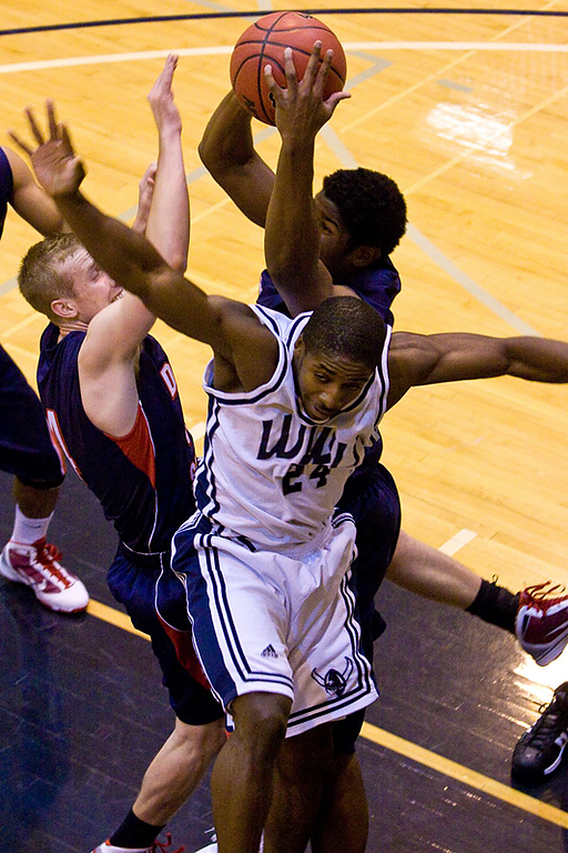 Two Dixie State defenders rip the rebound away from senior Vikings guard Andrew Ready on Tuesday. Photo by Jon Bergman | WWU intern