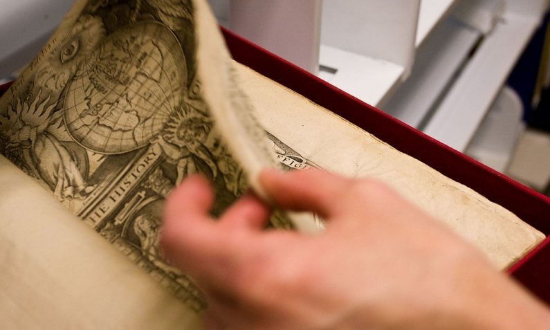 Special Collections manager Tamara Belts gently turns the page of author Sir Walter Raleigh's book "The Historie of the World." Photo by Jon Bergman | University Communications intern
