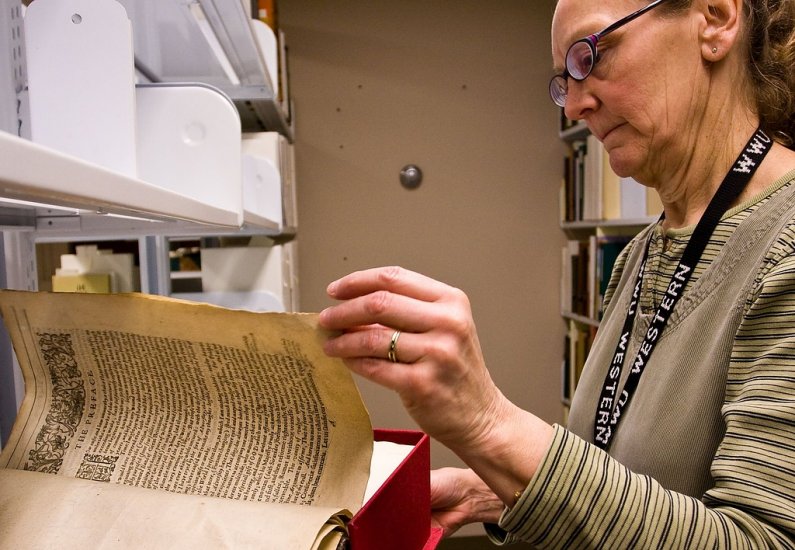 Special Collections manager Tamara Belts gently turns the page of author Sir Walter Raleigh's book "The Historie of the World." Photo by Jon Bergman | University Communications intern