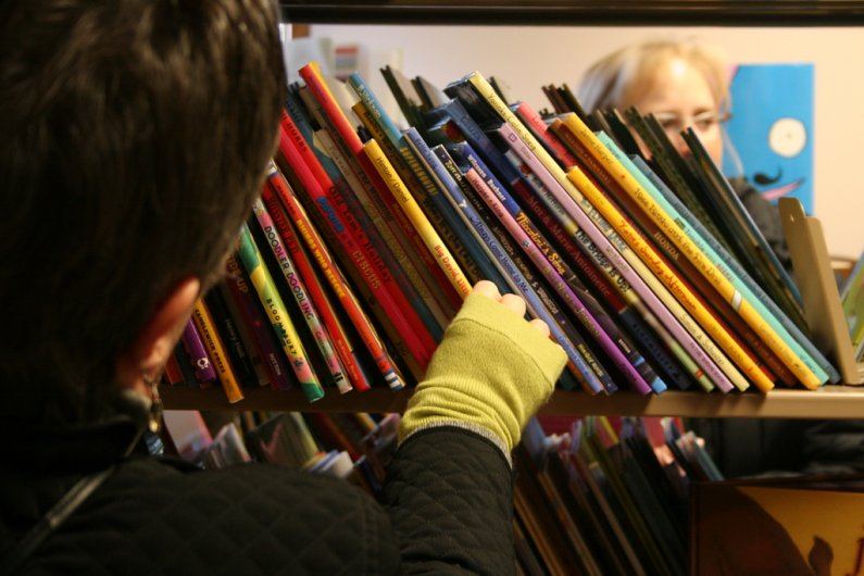 Shoppers pore through books available for purchase at the Children's Literature Book Sale in Wilson Library Room 171 on campus. The sale is taking place Dec. 3 and 4. Photo by Michael Leese | WWU intern