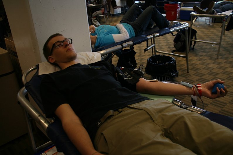 WWU freshman John Place, 19, donates blood in Viking Union Room 565 on Tuesday, April 19. Photo by David Gonzales | University Communications intern