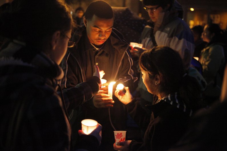 Western senior Lahaji Thomas helps the crowd light their candles during the Dr. Martin Luther King Jr. candlelight vigil; an event co-sponsored by the Ethnic Student Center and the Minority Employee Council, Thursday, Jan. 13, 2011 in Red Square. Photo by
