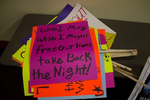 Signs for Take Back the Night's march downtown are piled in a corner of the Multipurpose room on Nov. 17. Photo by Christopher Wood|University Communications Intern