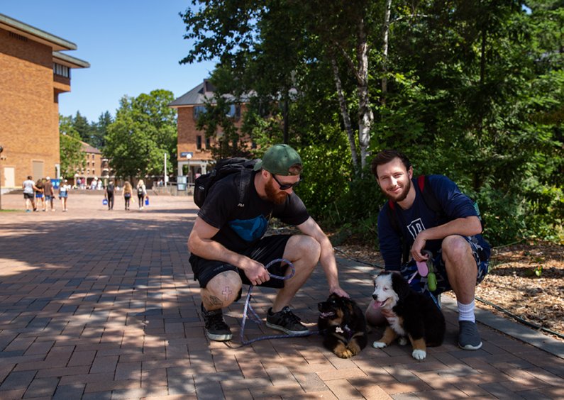 WWU Seniors Matt Motylewski and Chase Bates pose with their new puppies on campus on August 5, 2019