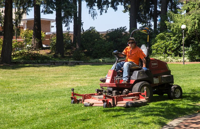 Facilities Management's Scott Vallejo enjoys the sun while mowing Old Main's lawn  on August 7, 2019.