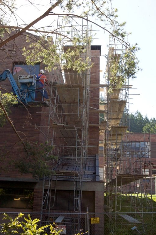 The Art Annex on the Western Washington University campus is swathed in scaffolding as workers repair the crumbling brick exterior of the building on Thursday, July 15. Photo by Matthew Anderson | University Communications