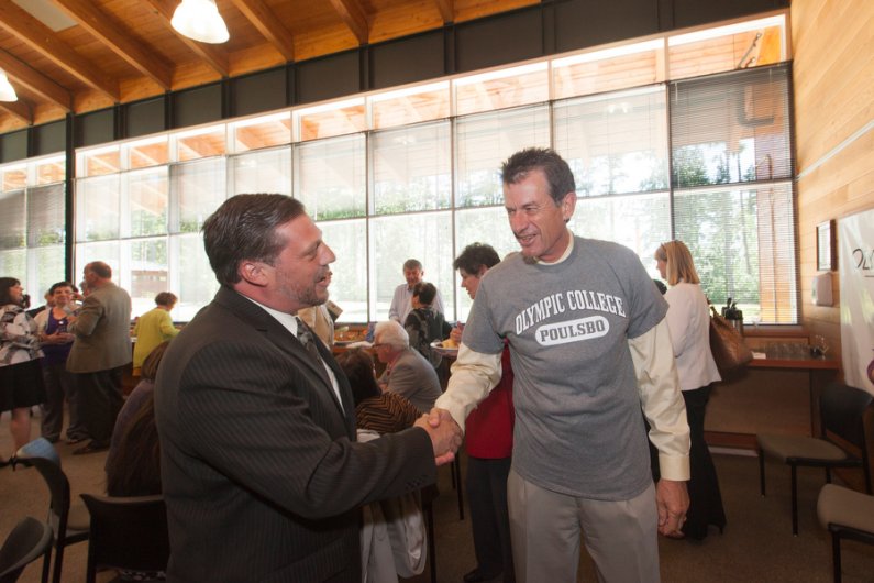 Western Washington University President Bruce Shepard shakes hands with Jim Funaro, director of OC Poulsbo, on Wednesday, July 17, at an event announcing Western's new partnership with OC to provide bachelor's degree programs on the Kitsap and Olympic pen