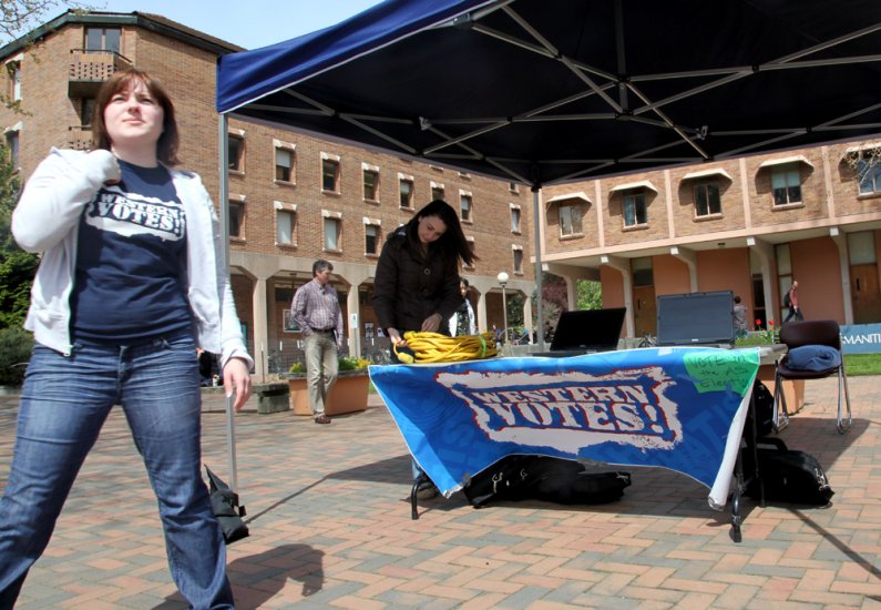 Western Washington University senior Nicole Brown, left, and freshman Kayla Warr monitor the Associated Students election booth on Friday, April 30, in Red Square. Voting was cut off at 2 p.m., and unofficial results should be available this evening. Resu