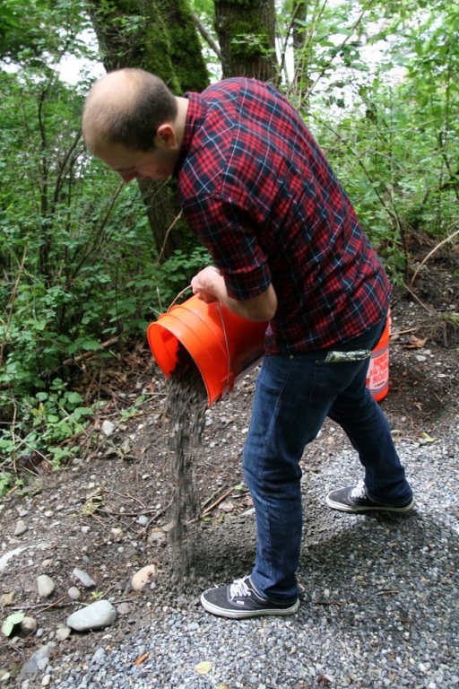 Western junior John Herbert, a Fairhaven student, dumps out buckets of gravel at the south campus arboretum shortcut trail behind Miller Hall Wednesday, June 2. The new trail and wooden stairway were constructed by the Geology 417D spring block instructed