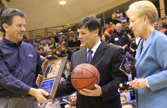 Western Washington University men's basketball coach Brad Jackson, center, receives an award commemorating his 500th career victory from President Bruce Shepard, left, and Athletic Director Lynda Goodrich before Wednesday night's basketball game against C