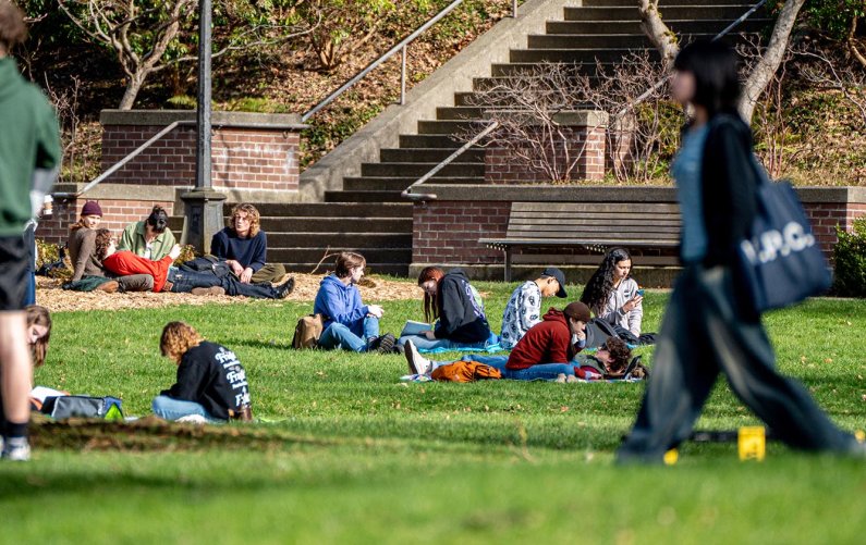 Students sit on blankets on the Old Main lawn, reading and chatting.