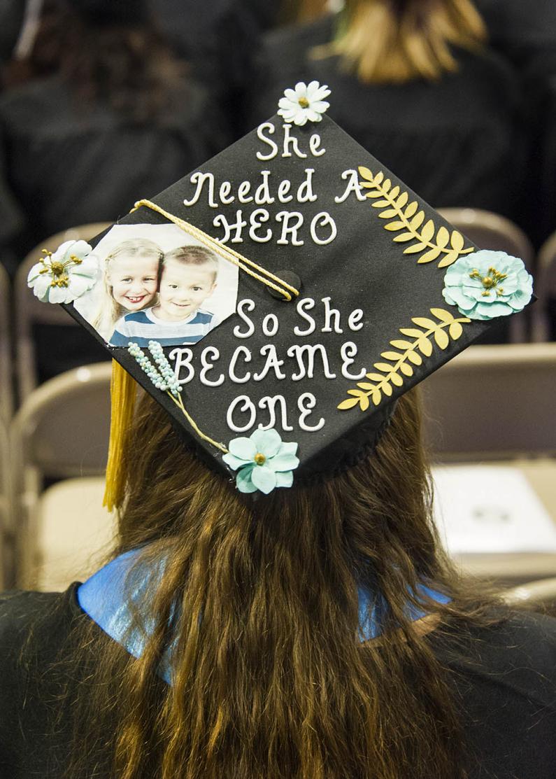 student's mortar board states "she needed a hero so she became one"