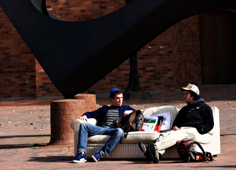 Western Washington University students Derek McFaul, left, a kinesiology major, and Robert Hamlin, a history major, chat on a couch in Red Square. The sun that these two were enjoying appears to be gone for a while, with forecasters predicting rain and hi