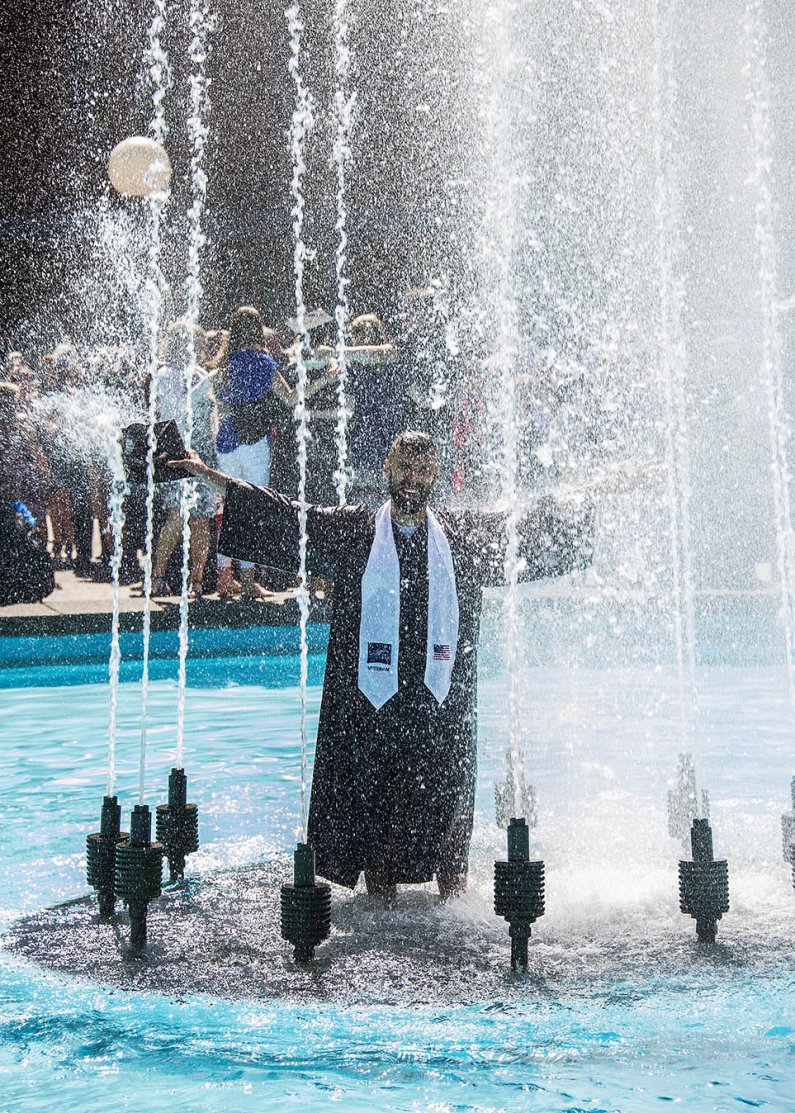 Management information systems graduate Brian Baldwin of Kirkland takes a celebratory shower in Fisher Fountain at WWU commencement Saturday, June 15, 2015. Photo by Dan Levine / for WWU